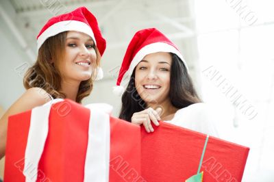 Young happy girls in Christmas hats.Standing together indoors an