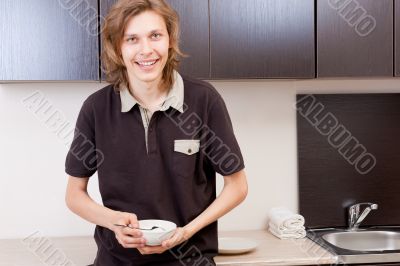 Happy young man after having a breakfast at home