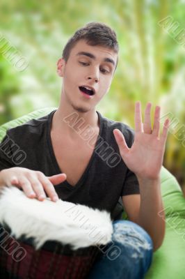 Happy young handsome man at home against palm tree, smiling and 