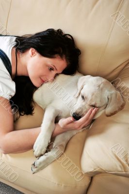 Young woman with dog sitting on sofa