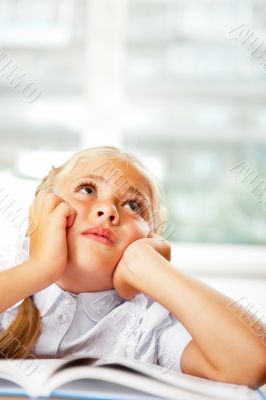 Portrait of a young girl in school at the desk.