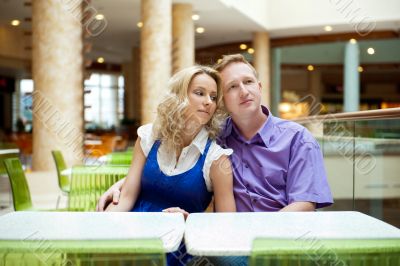 Portrait of a happy young couple looking away while sitting near