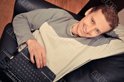 Happy young man  sitting on sofa at home