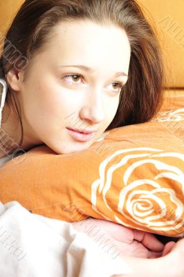 Closeup portrait of young pretty girl laying on her bed