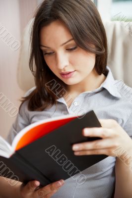 Young sexy woman at home reading book 