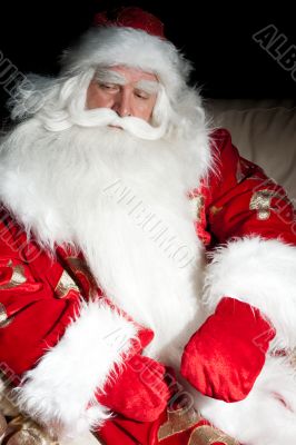 Santa sitting with a sack indoor at dark night room