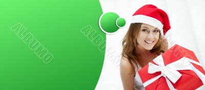 Young happy girl in Christmas hat. Standing indoors and holding 