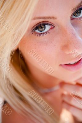 Portrait of pretty young woman standing outdoors near white wall