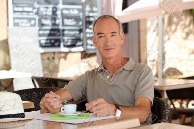 Man drinking coffee outside a cafe