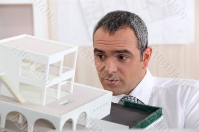 businessman holding an architectural model