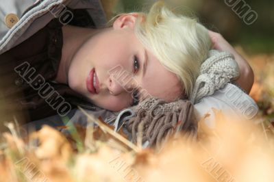 Blond woman laying in leaves
