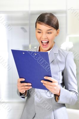 A portrait of a young business woman in an office with documents