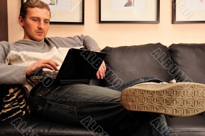 Happy young man  sitting on sofa at home