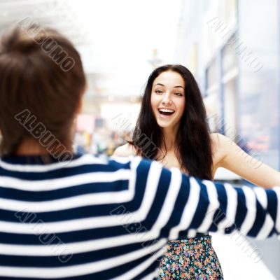 Young man meeting his girlfriend with opened arms at airport arr