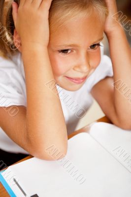 Image of smart child reading interesting book in classroom