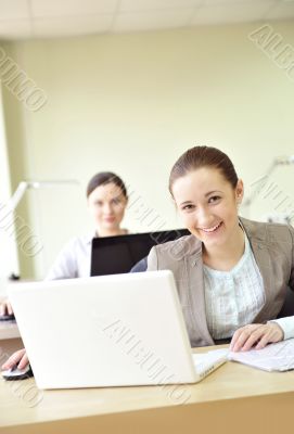 Portrait of two women working at their desks