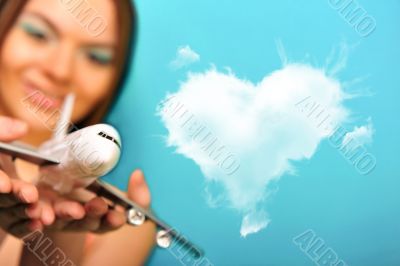 Pretty young woman playing with plastic airplane on green backgr