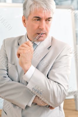 Closeup of a mature smiling business man standing in a light at 