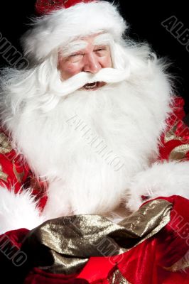 Santa sitting at the Christmas room and looking into the sack