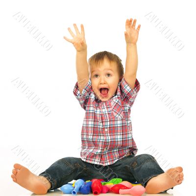 Little boy sitting and playing with balloons.
