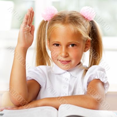 Portrait of a young girl in school at the desk.