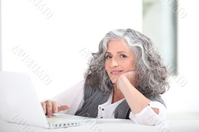 mature grey-haired lady with laptop