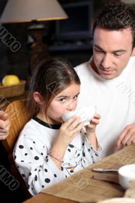 Man with little girl having breakfast