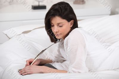 a woman writing diaries with a feather