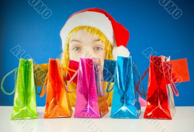 Teen girl looking from behind a row of colorful bags