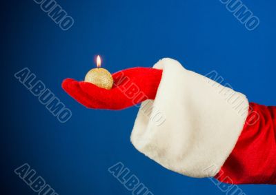 Santa`s hand holding a burning candle