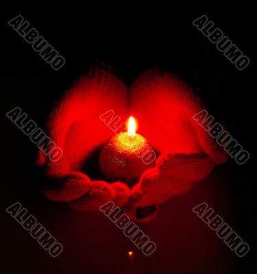 Human hands hold burning candle