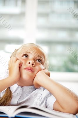 Portrait of a young girl in school at the desk.