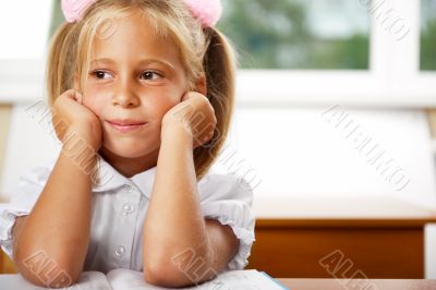 Image of smart child reading interesting book in classroom