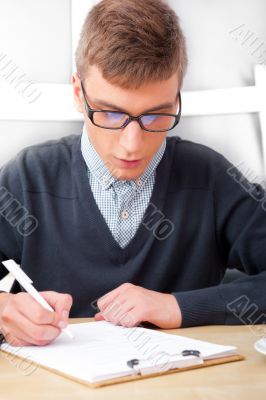 High school - Young male student write notes in classroom