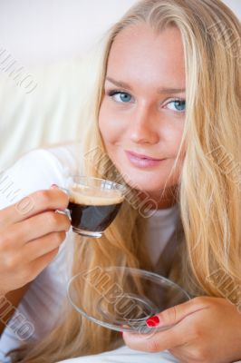 Closeup portrait of a pretty young female having a cup of coffee