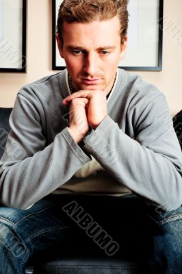 Closeup portrait of young man sitting on sofa 