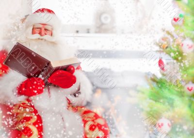 Santa sitting at the Christmas tree, near fireplace and reading 