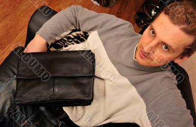 Happy young man sitting on sofa at home