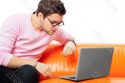 Closeup portrait of young man using laptop
