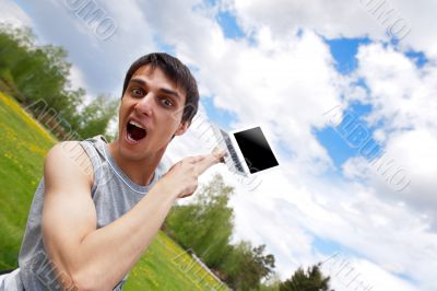 Happy young man with a laptop outdoors