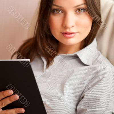 Portrait of a happy young brunette woman holding book