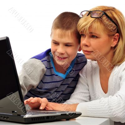 Portrait of adult woman watching as her son doing homework