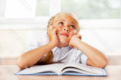 Portrait of a young girl in school at the desk.