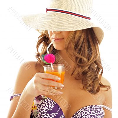 Woman drinking orange juice and wearing summer hat. Vacation con