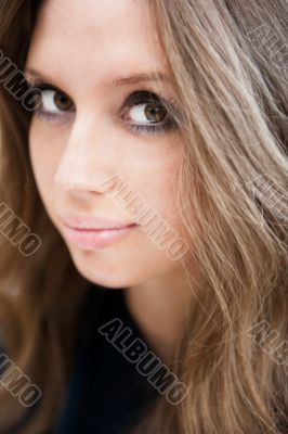 Pretty woman with long straight brown hair looking at camera