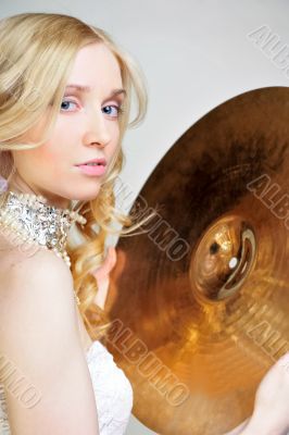Closeup portrait of fashionable woman holding cymbal and looking