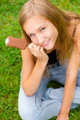 Portrait of young woman eating ice-cream while sitting relaxed o