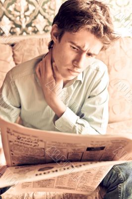 Closeup portrait of young man with newspaper 