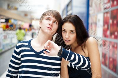 Portrait of young couple standing together at airport hall and l