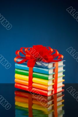 Stack of colorful books tied up with red ribbon